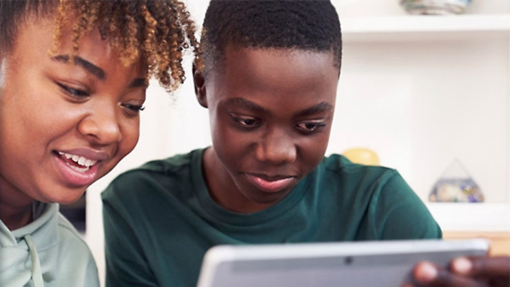 とタブレットを見ている人物と横からそのタブレットをのぞき込む人物