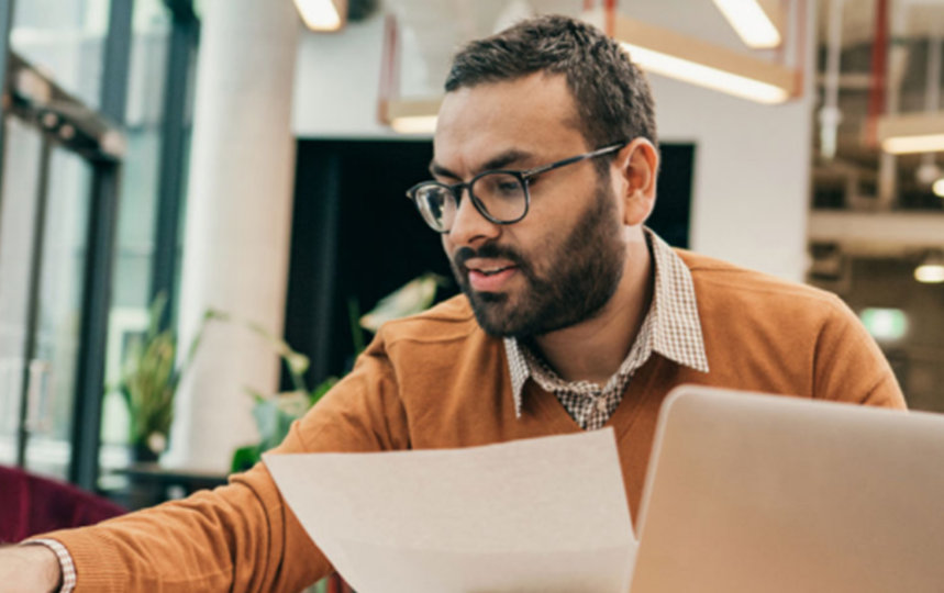 A financial advisor works at a table in a shared office space.