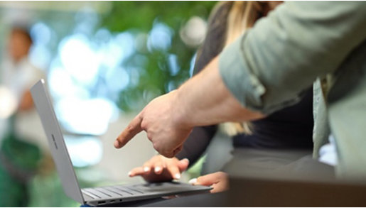 A man pointing to the Microsoft Devices Sustainability Report on a Microsoft laptop