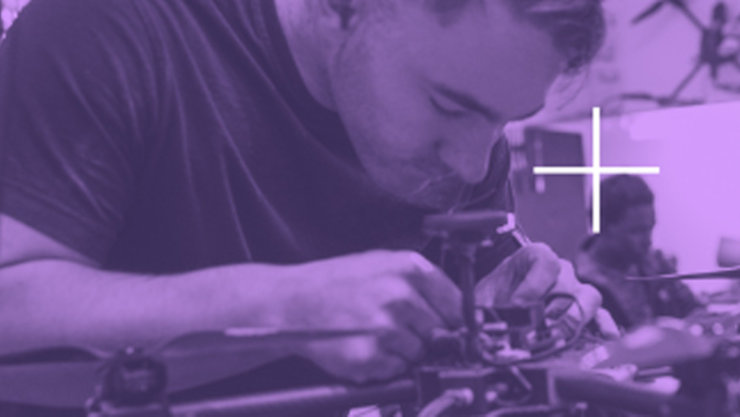 A purple overlay over a background showing a man fixing some hardware