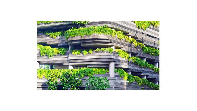A building with green plants hanging iver its railings