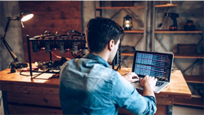 A student writing code on his laptop