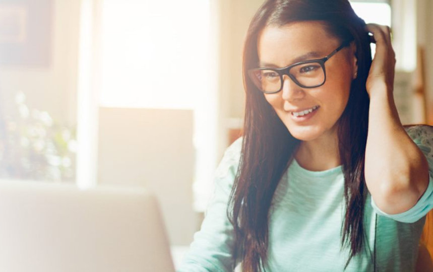 A student wearing glasses and working on her laptop