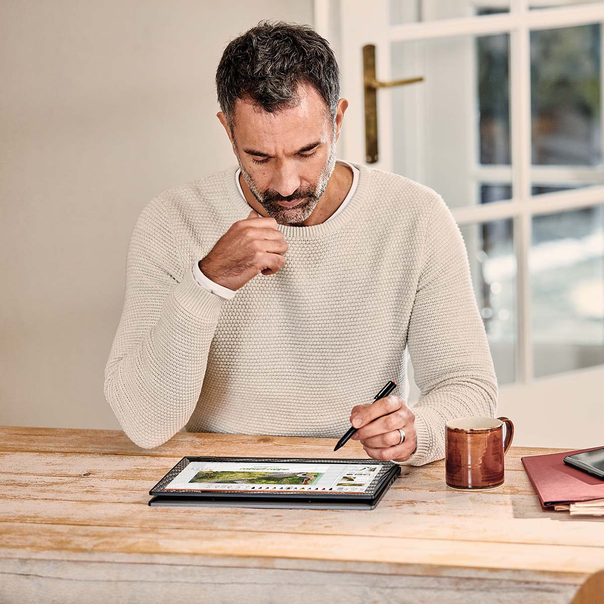 A Male business owner working at home desk on his tablet