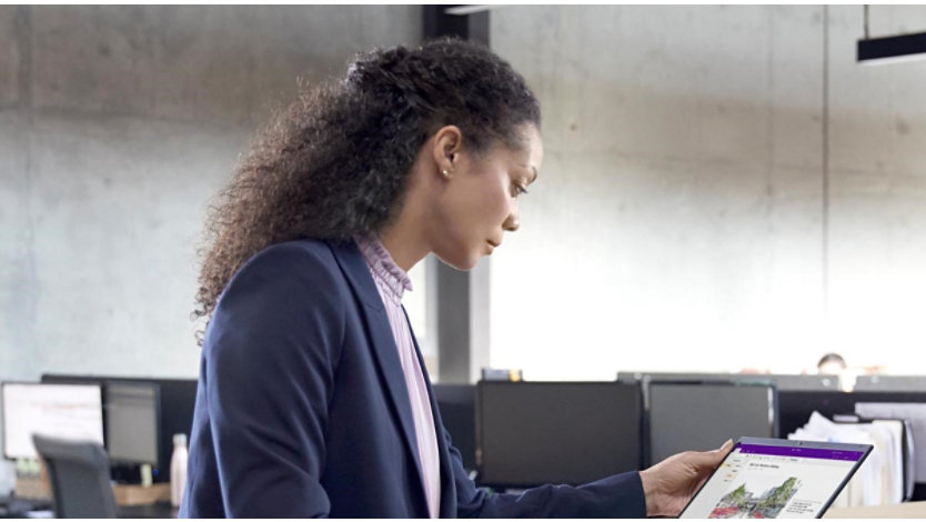 A female professional in office setting working on a standing desk