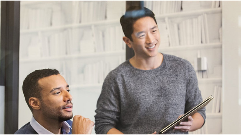 Two male co-workers are woking together in an office setting 