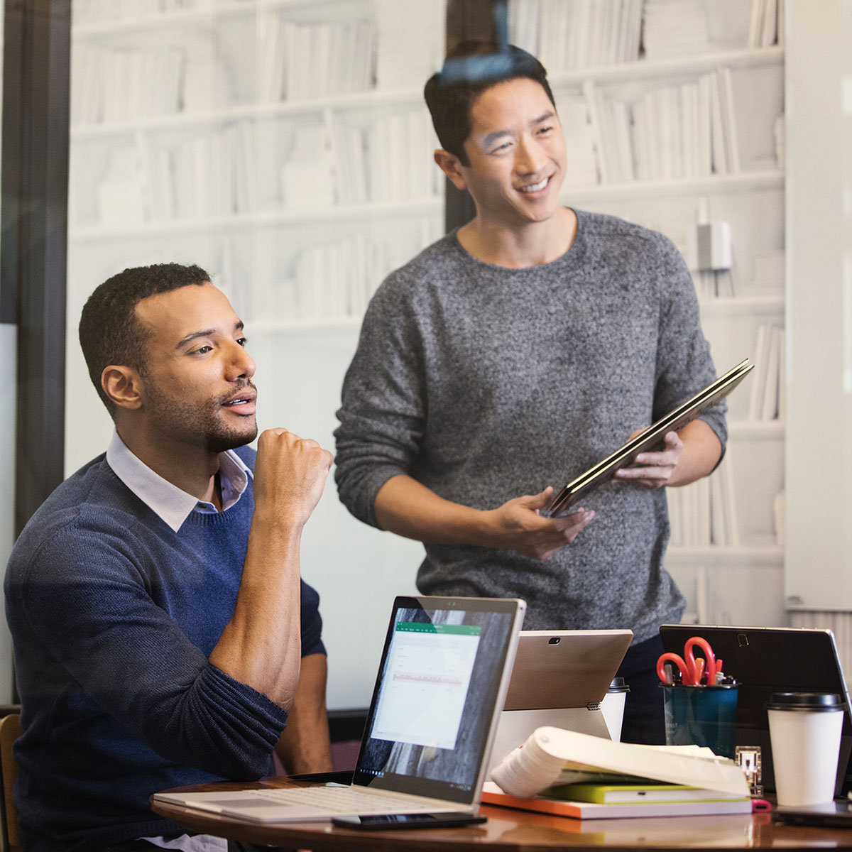 Two male co-workers are woking together in an office setting