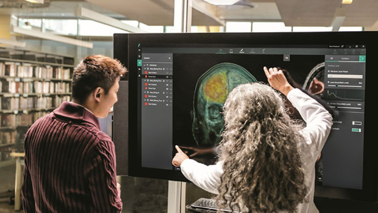 Une femme médecin utilise l'IA pour montrer une image de cerveau.
