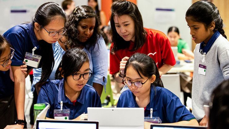 Students look over a computer during a contest.