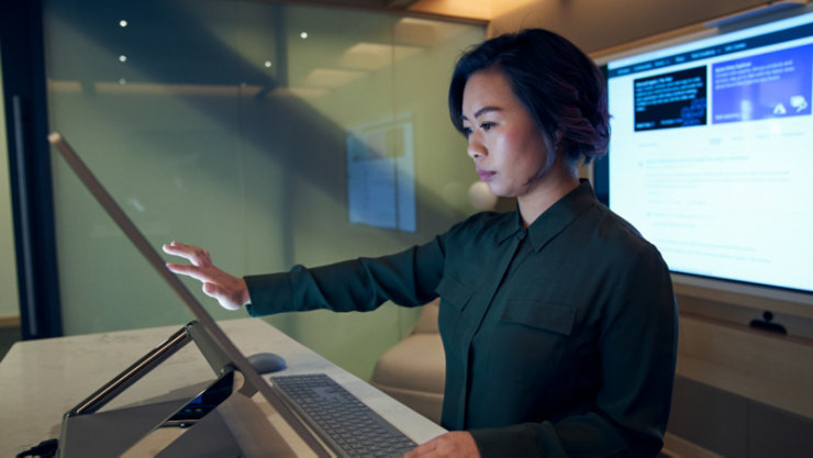 Une cadre en train de travailler sur un appareil avec un grand écran tactile