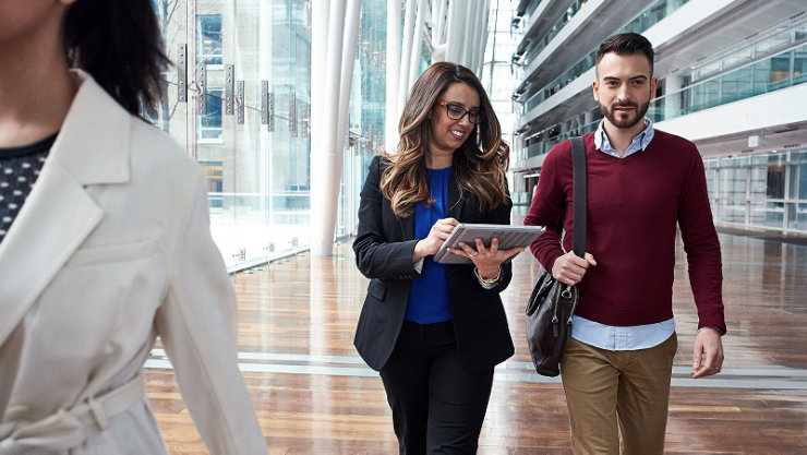 Des cadres masculins et féminins discutant de leur travail pendant qu'ils travaillent