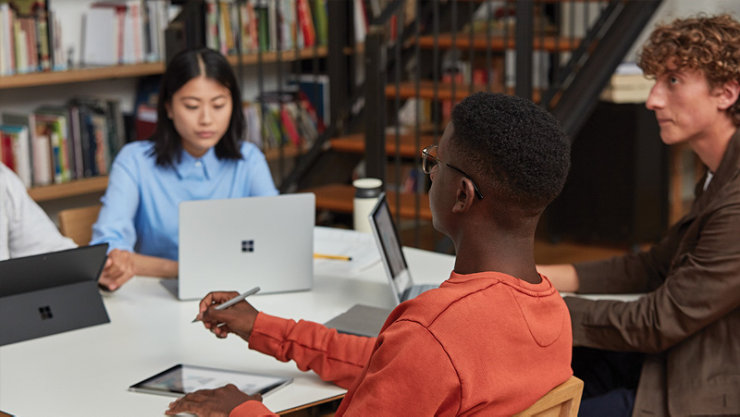 Un groupe de quatre étudiants tapant sur leurs appareils Surface