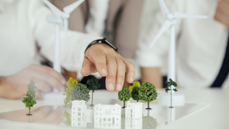 Deux cadres du gouvernement discutent des plans de développement durable de la ville à l'aide d'une maquette miniature.