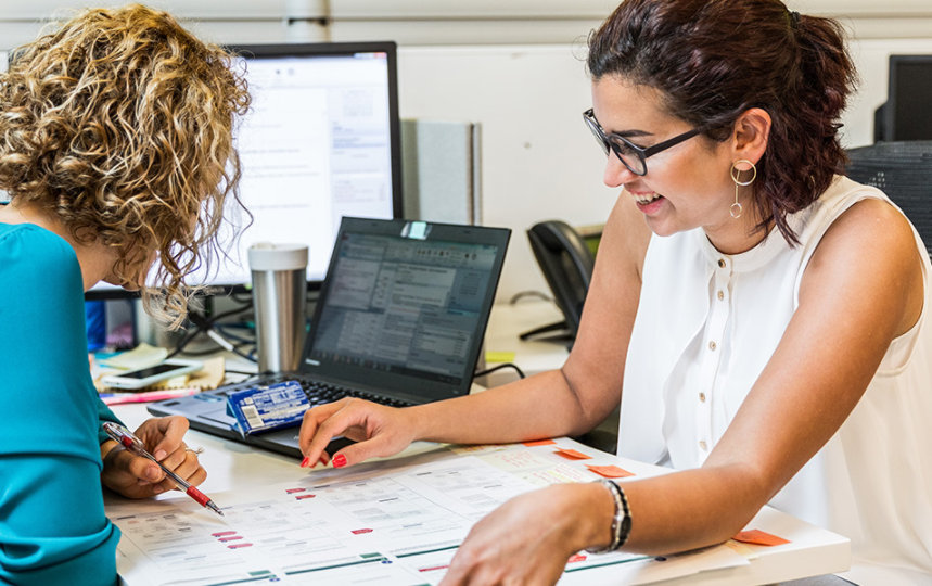 Two women looking at a printed financial report