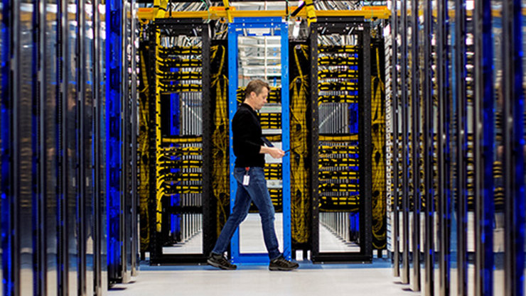 Server room, one employee walking past the servers