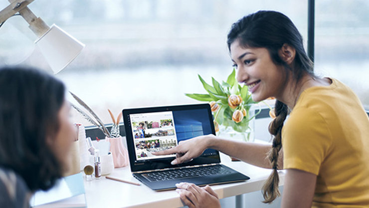 Two women working together on a laptop