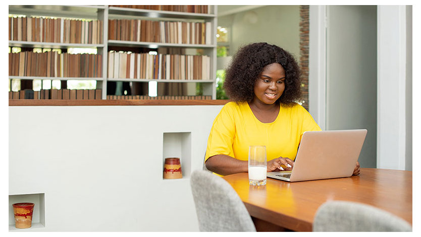 women sitting at a table working on her computer