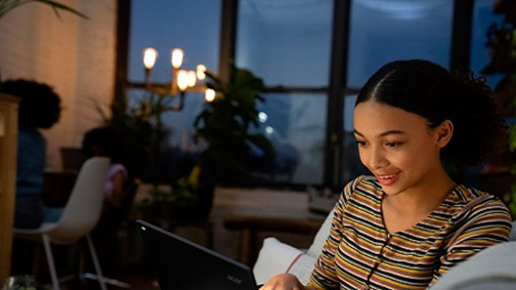 Young woman working with laptop in living room.