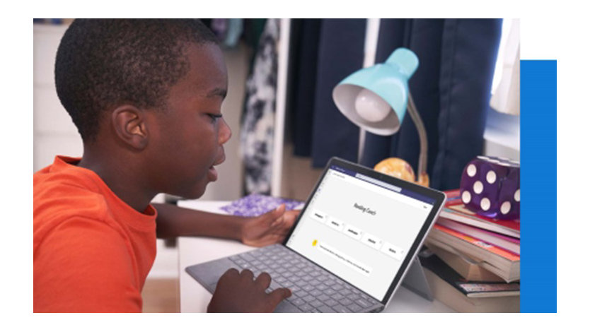 Young male student sits at a desk using device