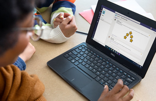 woman sitting at a table using a laptop