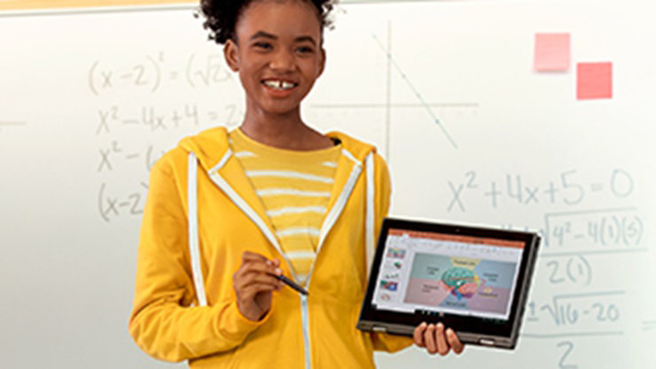 a girl standing in front of a white board holding a device