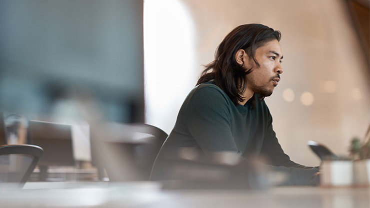 Enterprise office worker in focused work with a neutral facial expression.