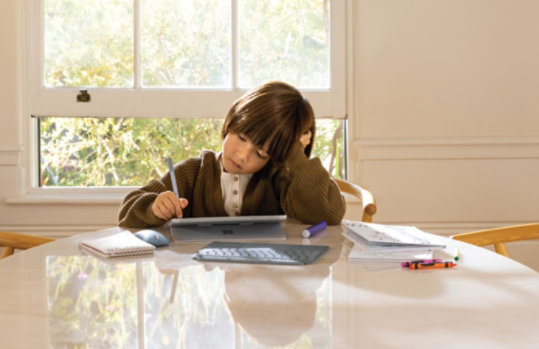 young boy works on device