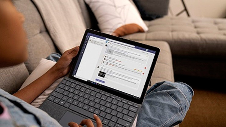 K-12 student sits with device using Microsoft Teams