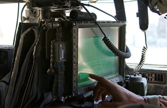 Soldier uses a touchscreen monitor aboard a helicopter