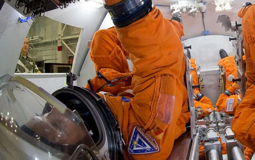 Suited personnel in a Orion mockup capsule