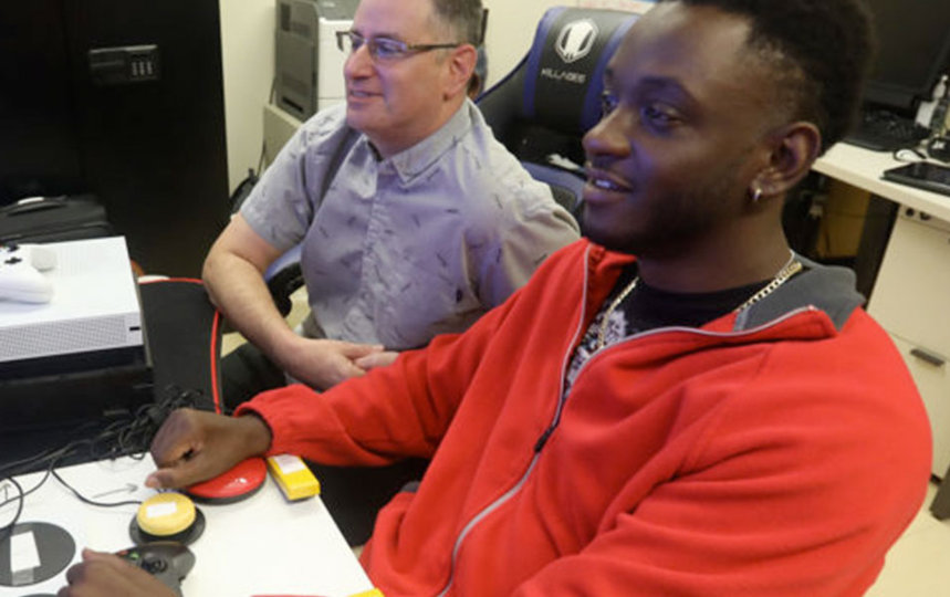 VA recreation therapist Jamie Kaplan, left, looks on as Mike Monthervil plays a game