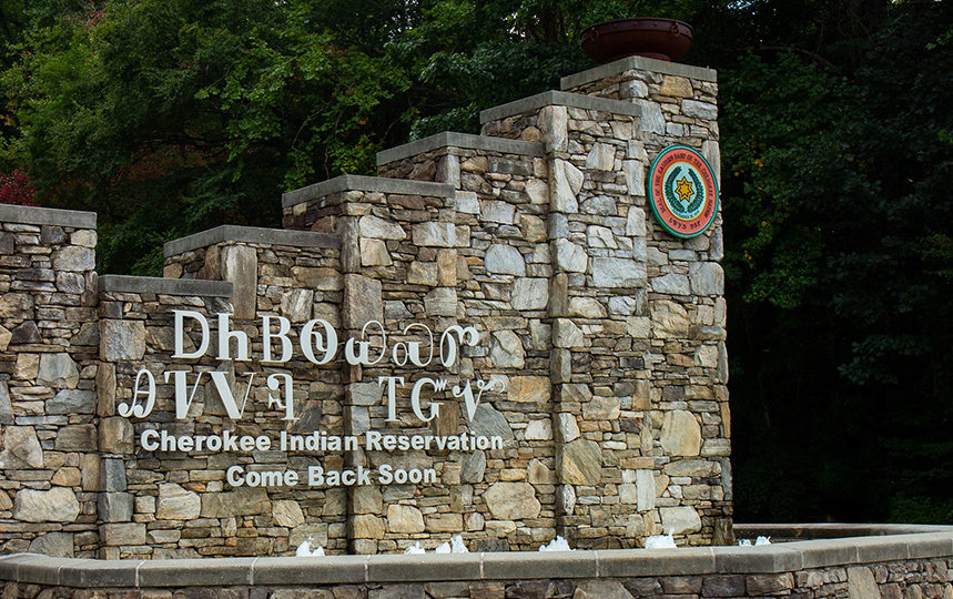 A stonework welcome sign for the Eastern Band of Cherokee Indians’ reservation in Cherokee, North Carolina. The sign is written using both the Cherokee syllabary as well as the English translation which reads ‘Cherokee Indian Reservation / Come Back Soon.’