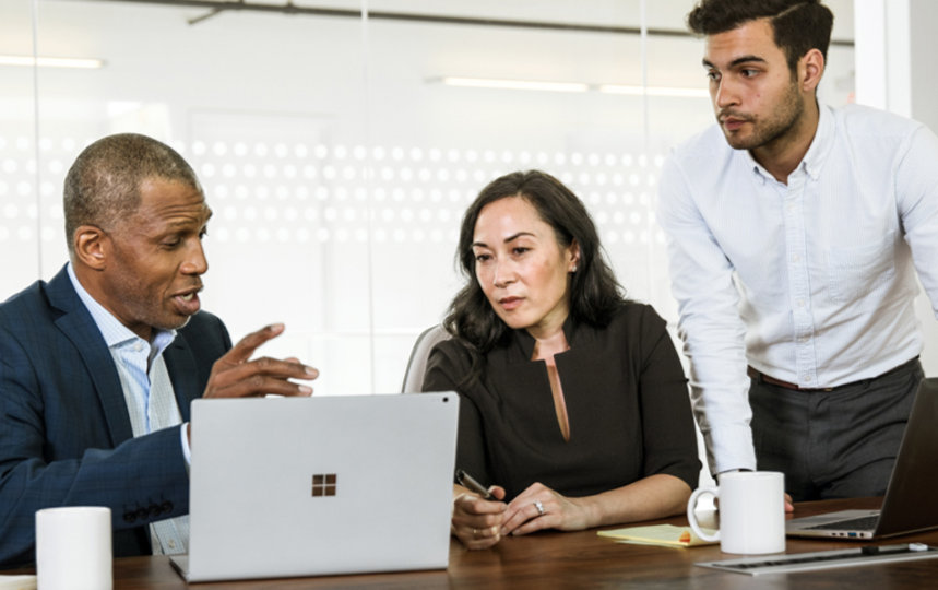 Coworkers sitting at conference table, discussing business