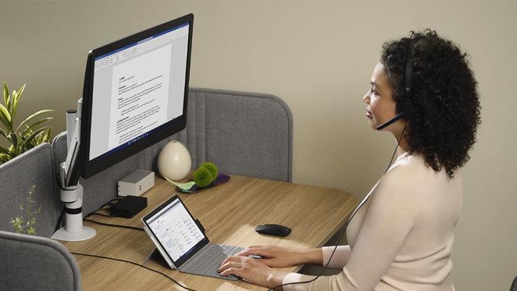 woman works on a document at her office desk