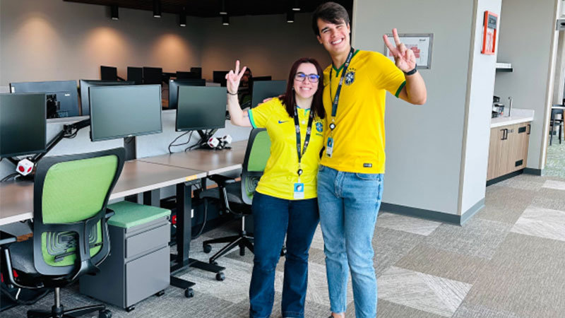 Dos personas dentro de una oficina sonriendo a la cámara.