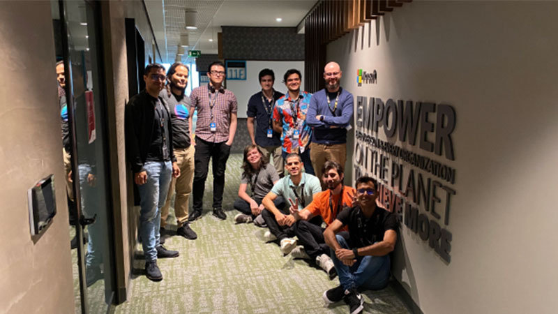 Algunas personas posando para una foto en el pasillo de una oficina.