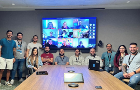 Varias personas frente a un televisor participando en una videoconferencia.
