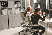 Two federal healthcare researchers working in a shared open office space.