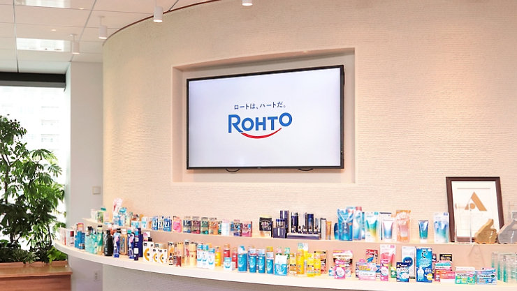 「Rohto」のロゴが表示されたモニターと、様々な製品が並ぶ展示スペース。