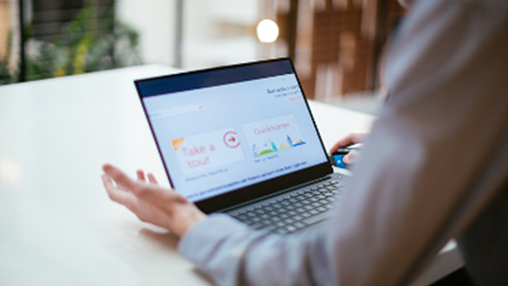 Gezeigt wird ein Laptop, den eine Person bedient