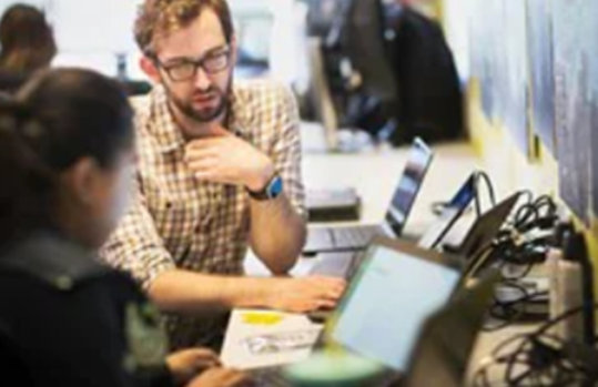 Ein Mann und eine Frau sehen in einen Laptop