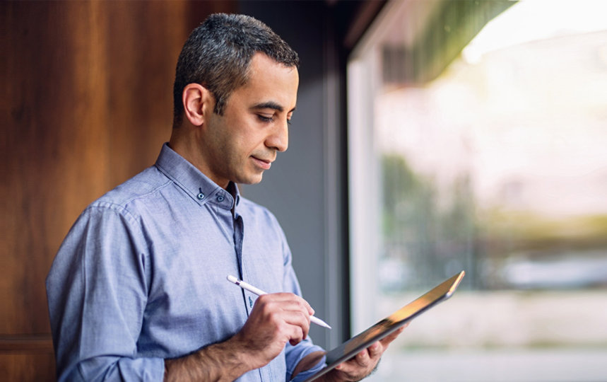 Businessman wearing casual clothing holding a digital tablet using a stylus