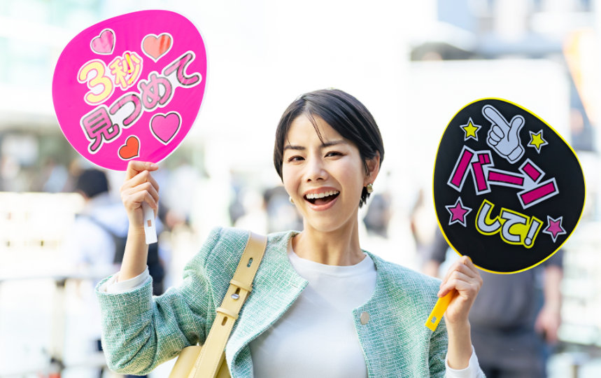 推し活用の手作りをうちわを両手に持った人物