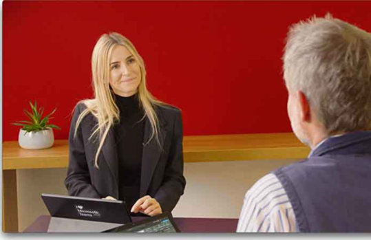 Eine Frau und ein Mann stehen an einem Tisch und unterhalten sich