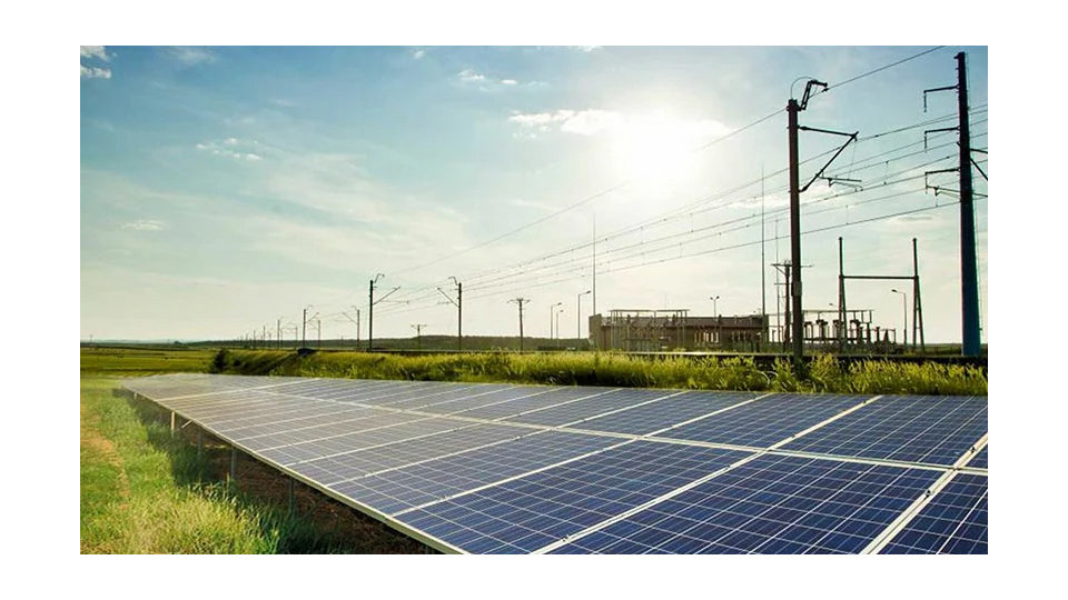 A solar panel installed on an open field next to a power plant