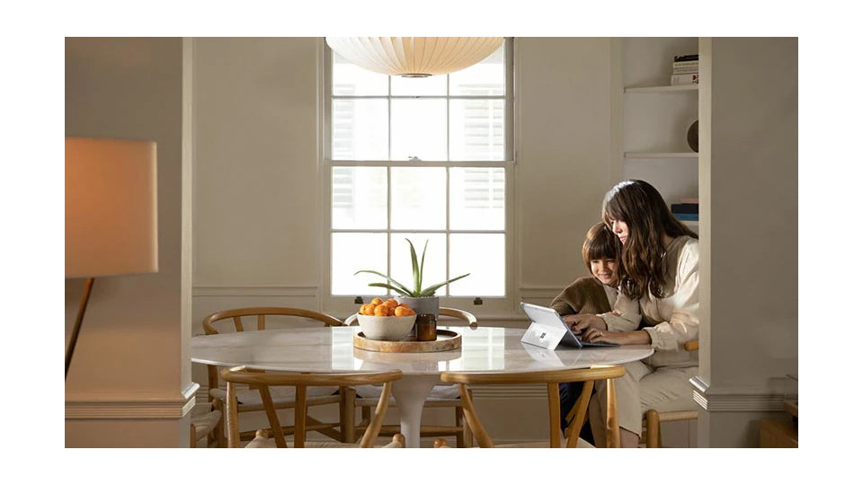 women working on tab with her child at home