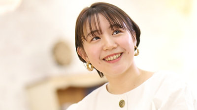 白い服を着て笑顔で上を見上げる本藤美波さん