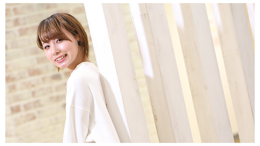  短い茶色の髪をした笑顔の女性が肩越しにちらっと見えます。