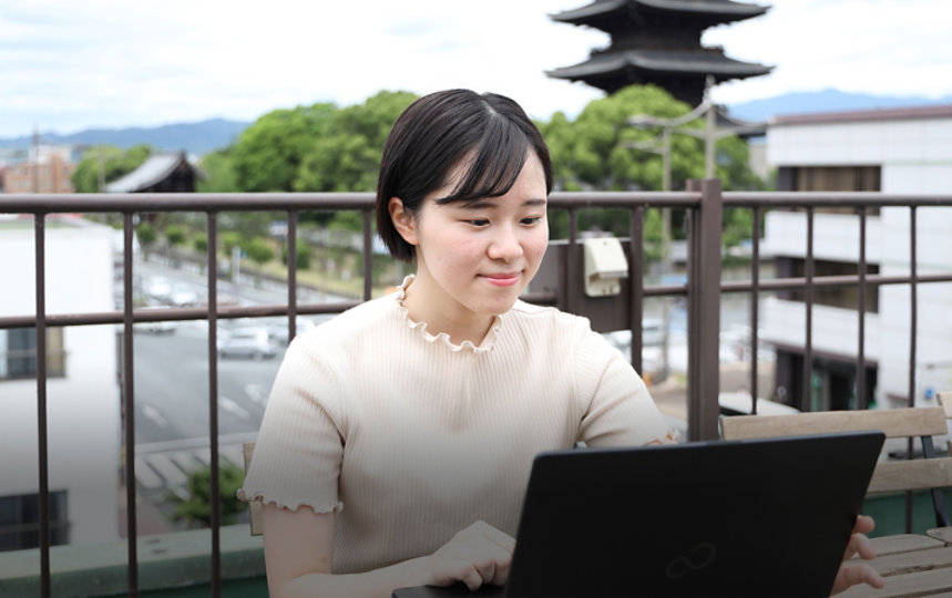 屋外でノートパソコンで作業する内田康穂