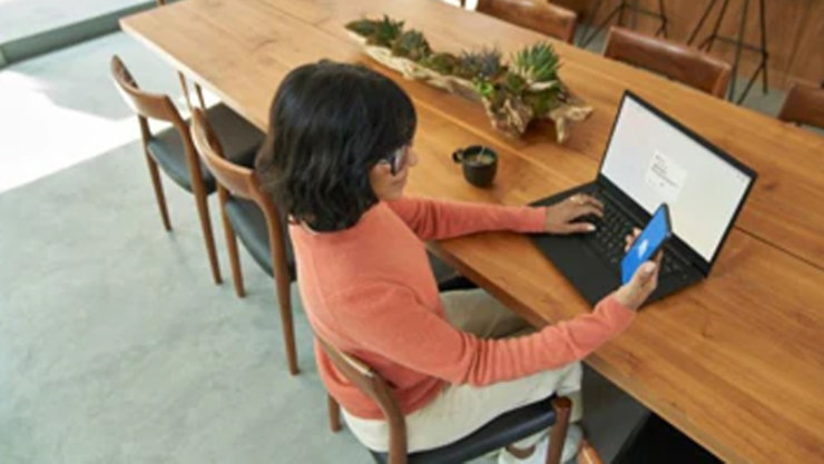 パソコンとスマートフォンで作業をする女性